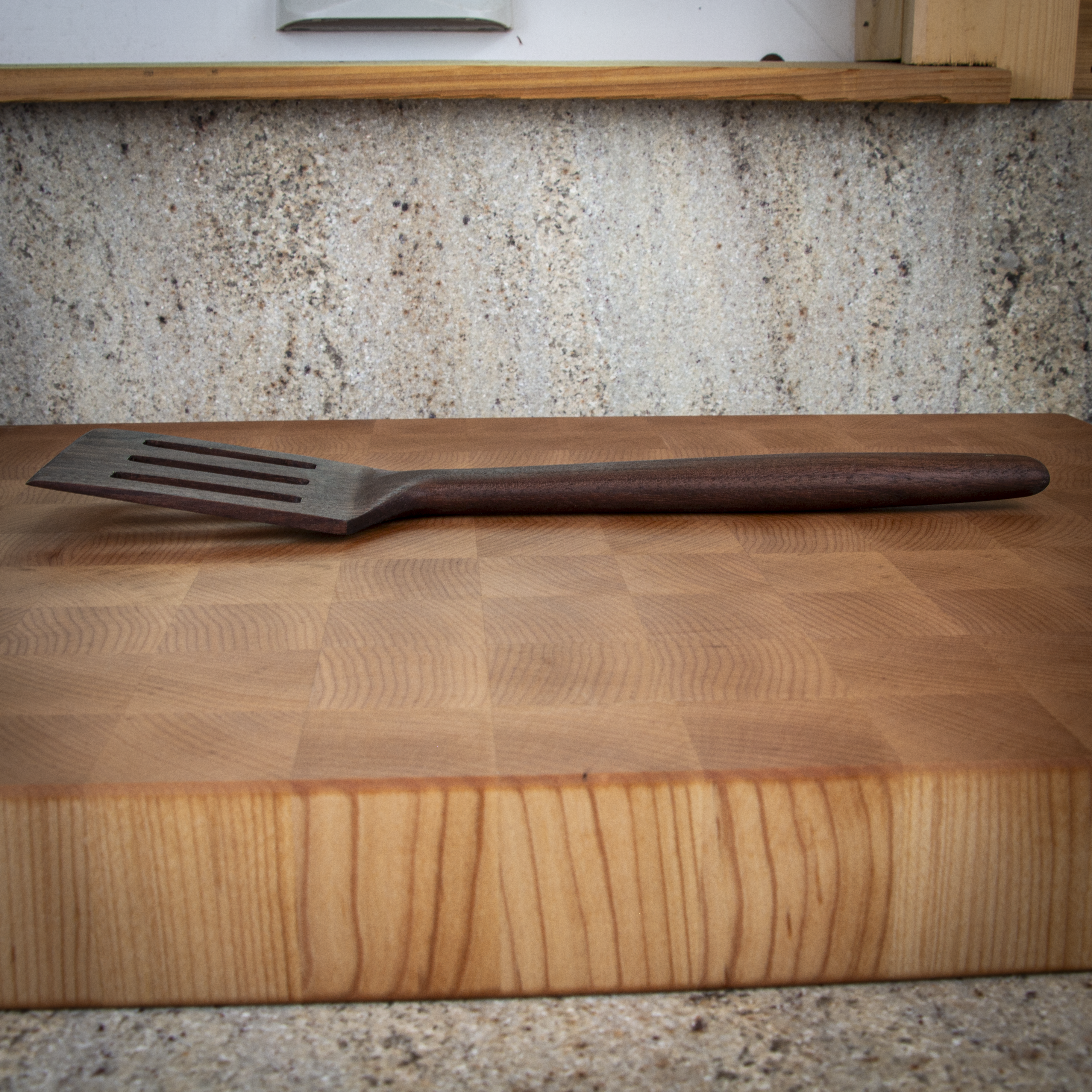 Slotted wood turner spatula for flipping and draining in the kitchen