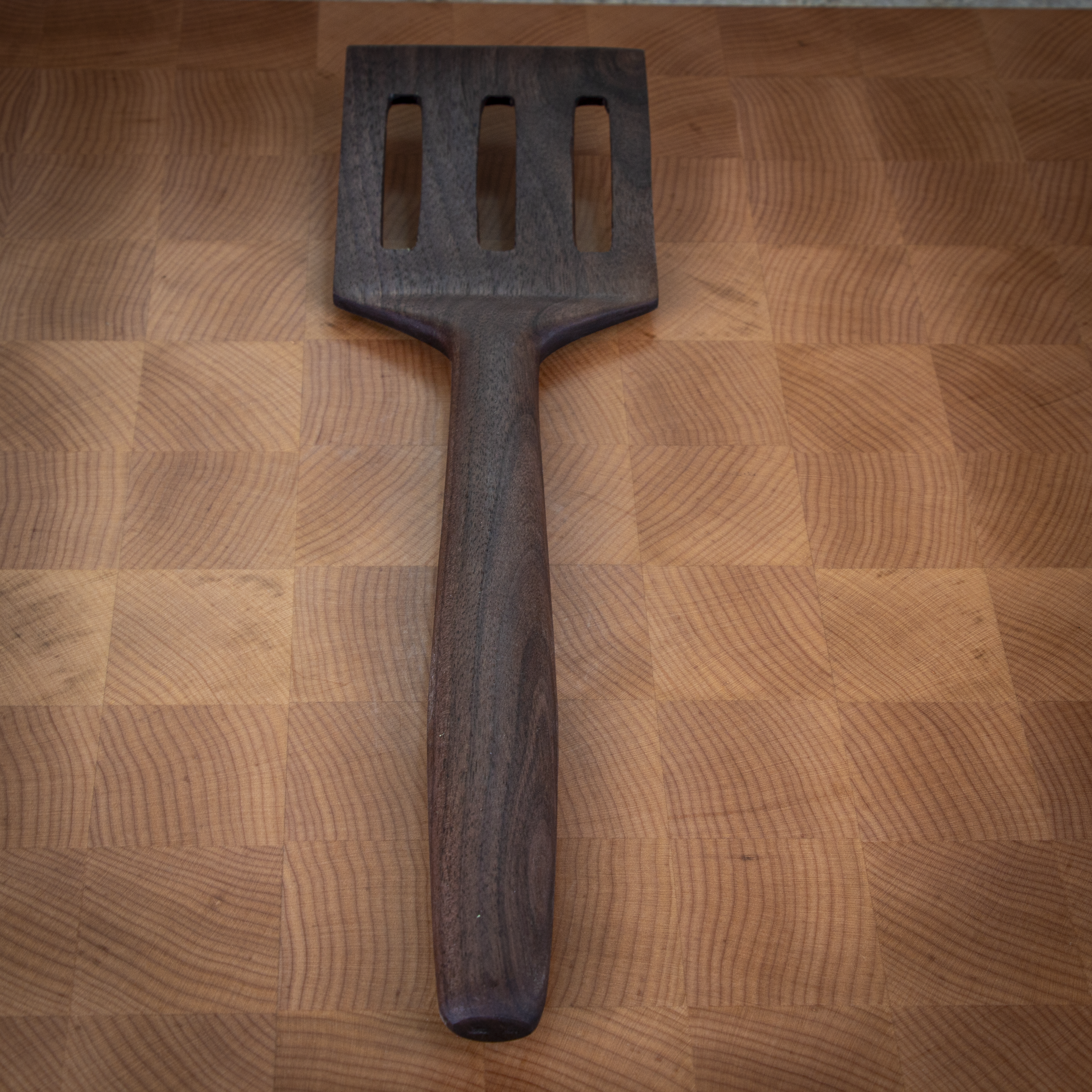 Slotted wood turner spatula for flipping and draining in the kitchen