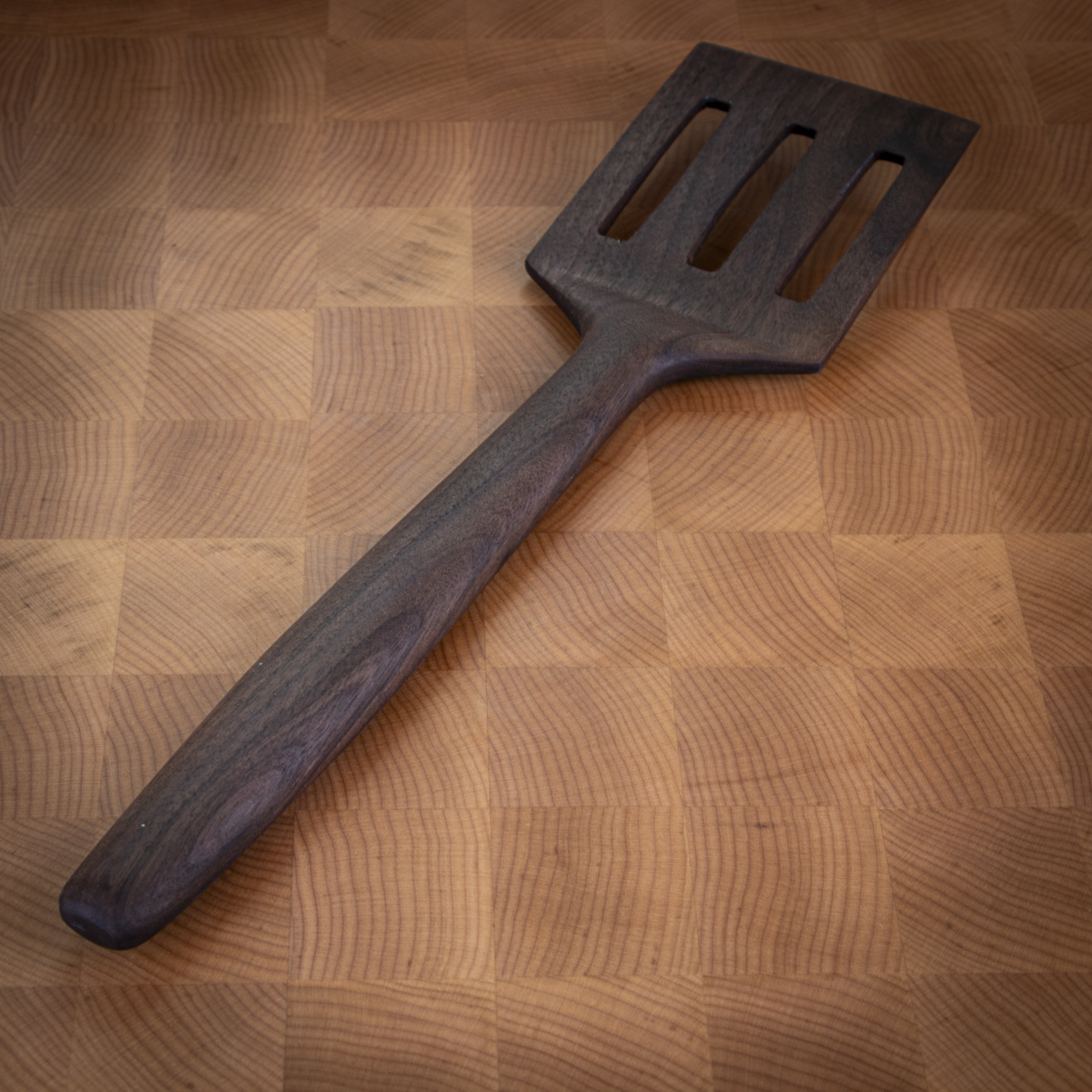 Slotted wood turner spatula for flipping and draining in the kitchen