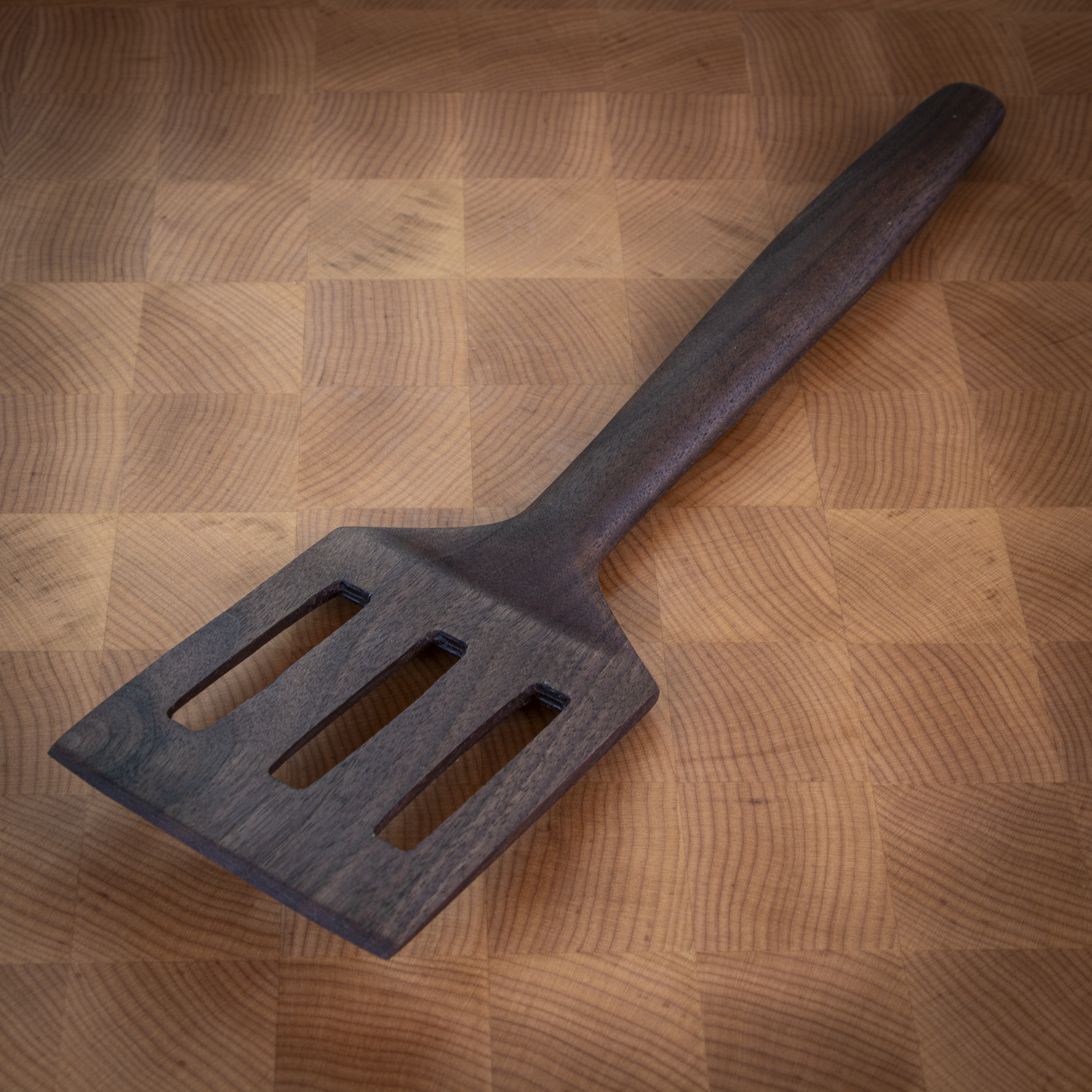 Slotted wood turner spatula for flipping and draining in the kitchen