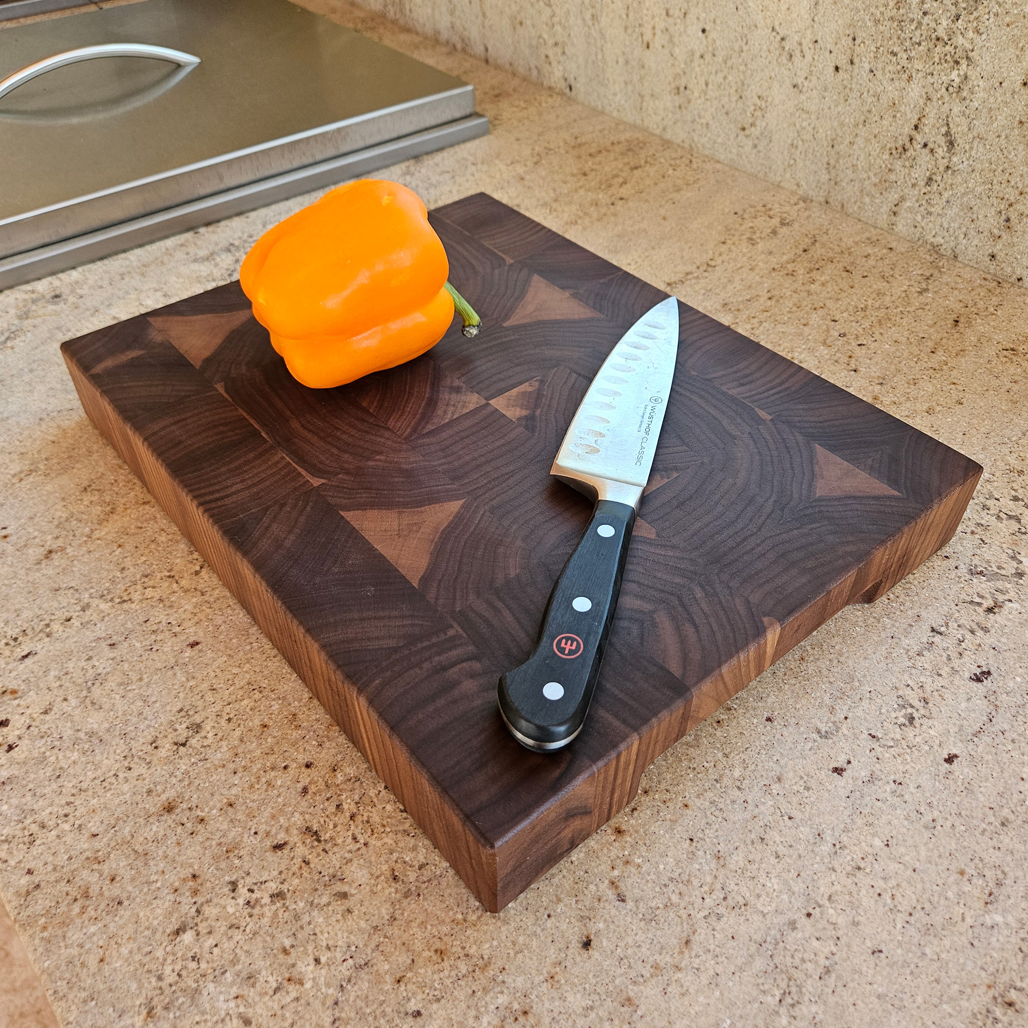 End grain walnut cutting board on countertop for prep and serving