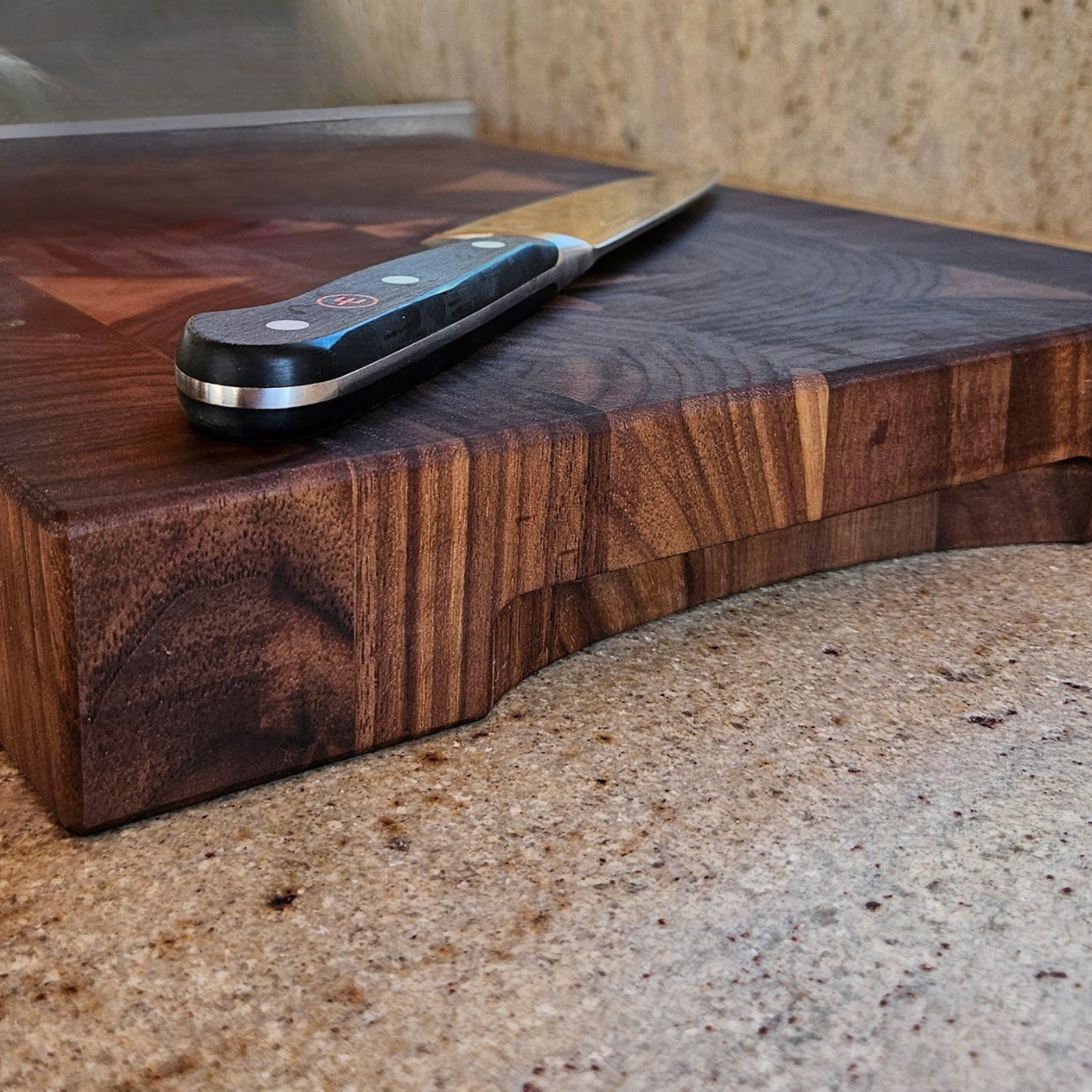 End grain walnut cutting board on countertop for prep and serving